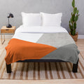 Grey orange and concrete color block plush blanket with geometric pattern