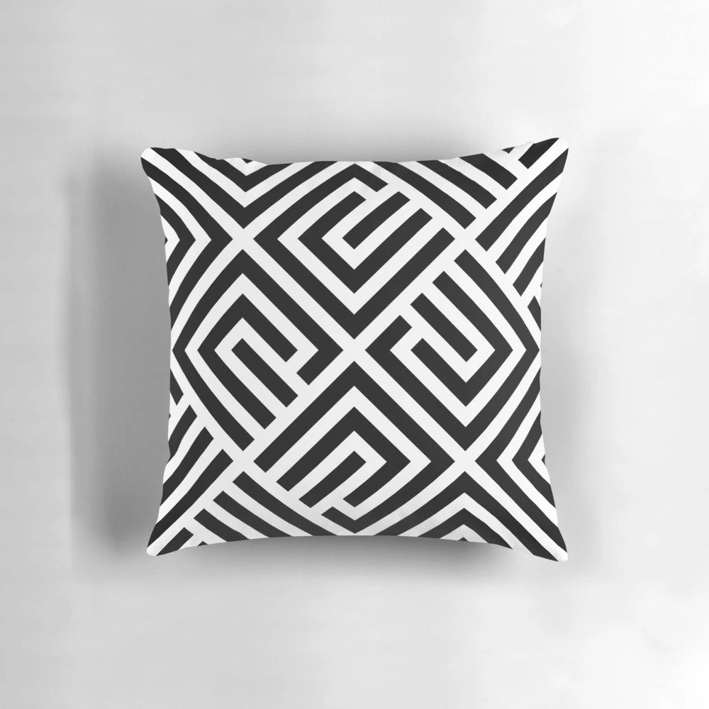 A square throw pillow featuring a geometric labyrinth pattern in black and white.