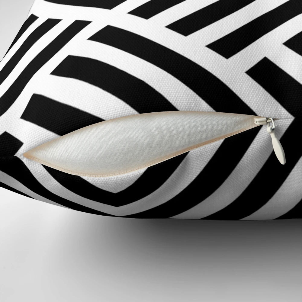 A square throw pillow featuring a geometric labyrinth pattern in black and white.