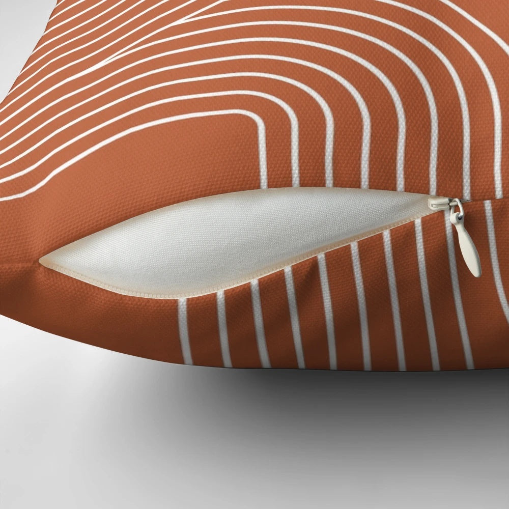 A modern, minimalist throw pillow featuring a mid-century inspired line art design in terracotta and white.