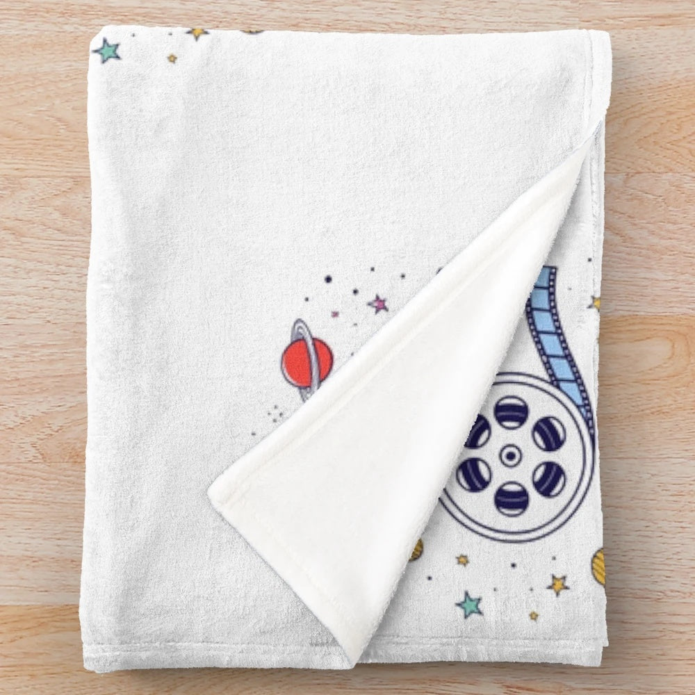 Illustration of a movie reel against a cosmic universe background on a plush blanket