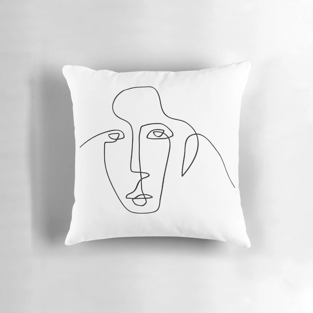 A black and white minimalist throw pillow featuring a simple, continuous line drawing of a face.