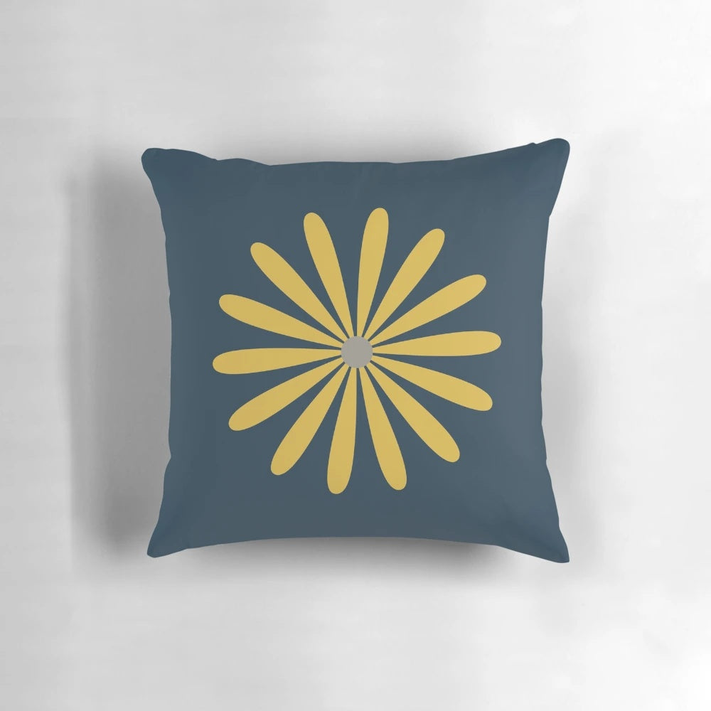 A minimalist, retro-modern navy blue throw pillow with a light mustard and grey daisy floral pattern.