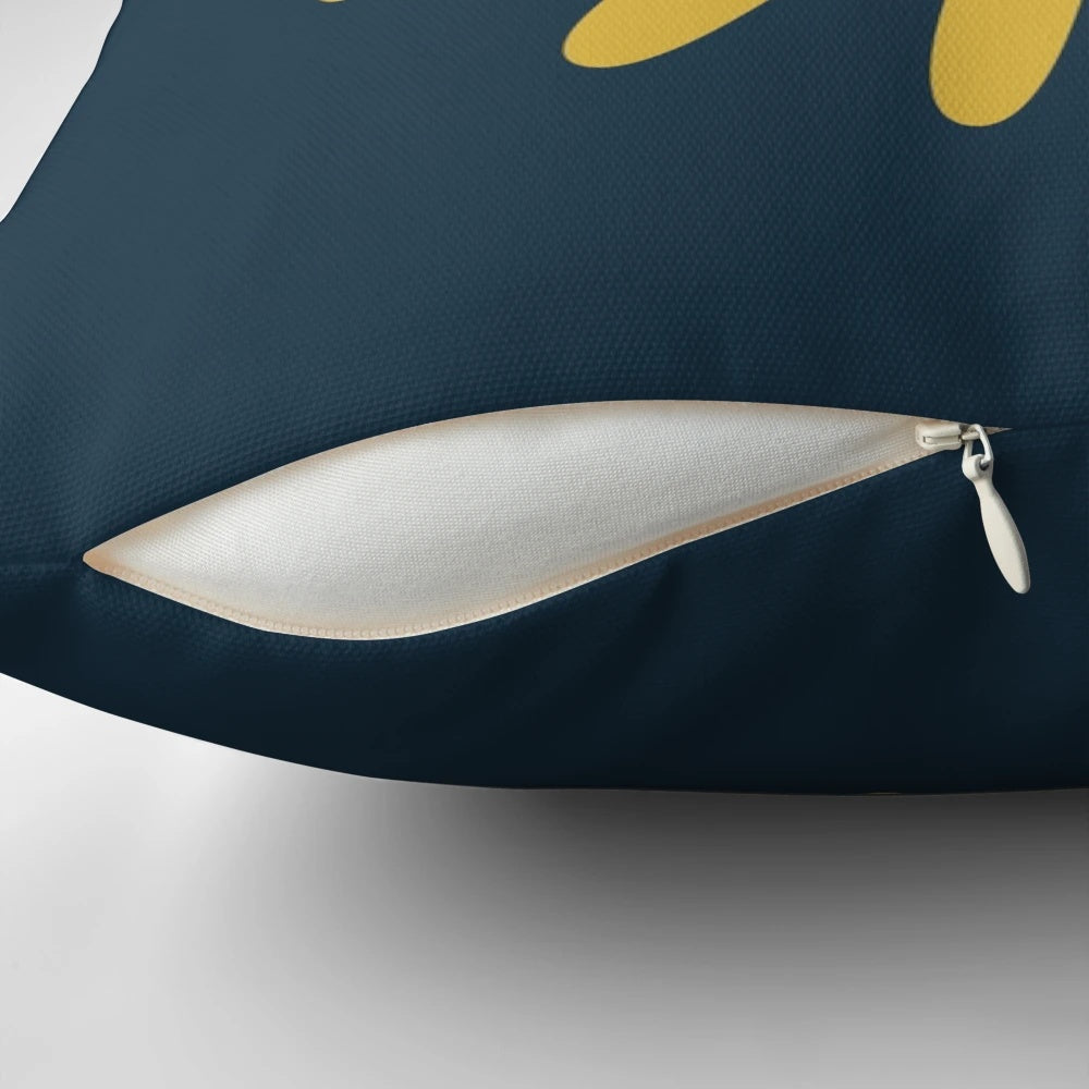 A minimalist, retro-modern navy blue throw pillow with a light mustard and grey daisy floral pattern.