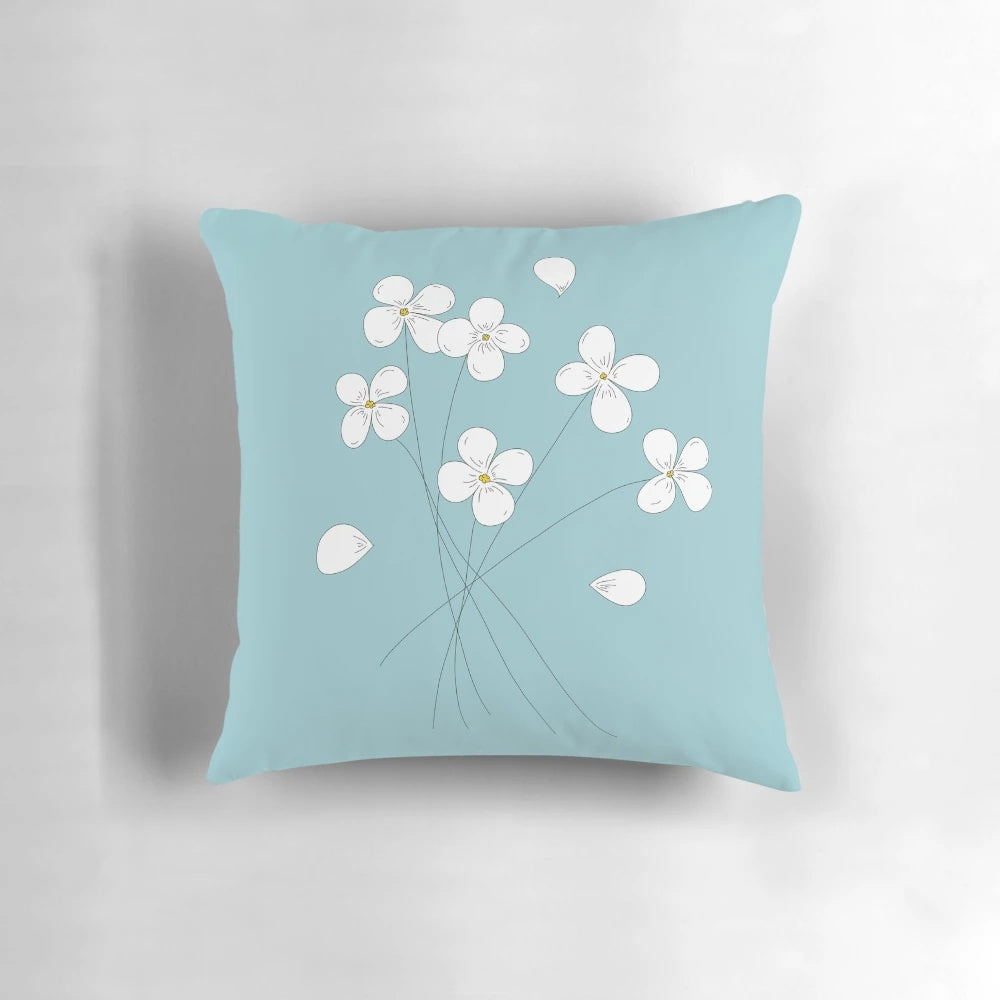 A minimalistic white flowers decorative pillow with soft pastel blue accents, perfect for nature-inspired home decor.