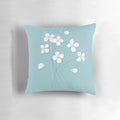 A minimalistic white flowers decorative pillow with soft pastel blue accents, perfect for nature-inspired home decor.
