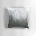 A cozy pillow featuring a misty, evergreen forest landscape in a vintage, fairytale style.