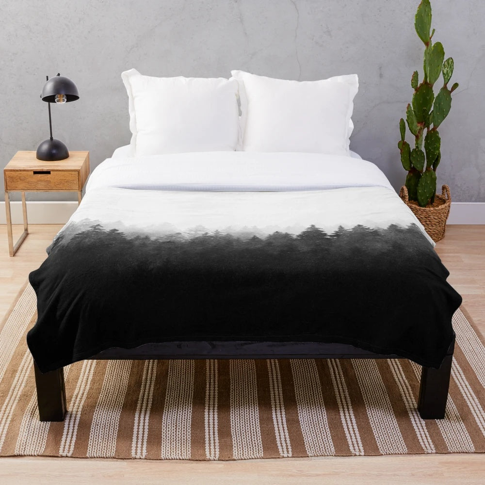 Plush blanket featuring a misty, romantic forest landscape with trees and cascading fog