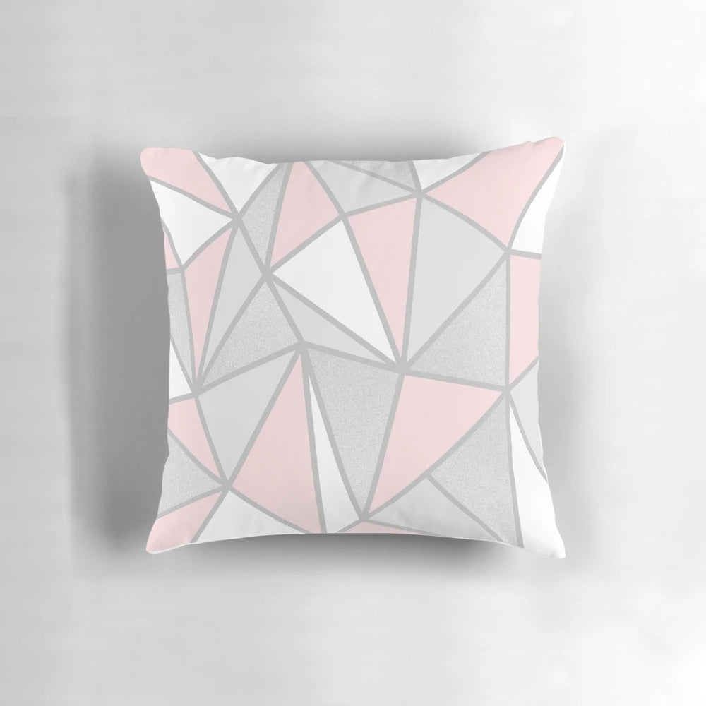A soft, modern grey and pink geometric throw pillow with a contemporary abstract design