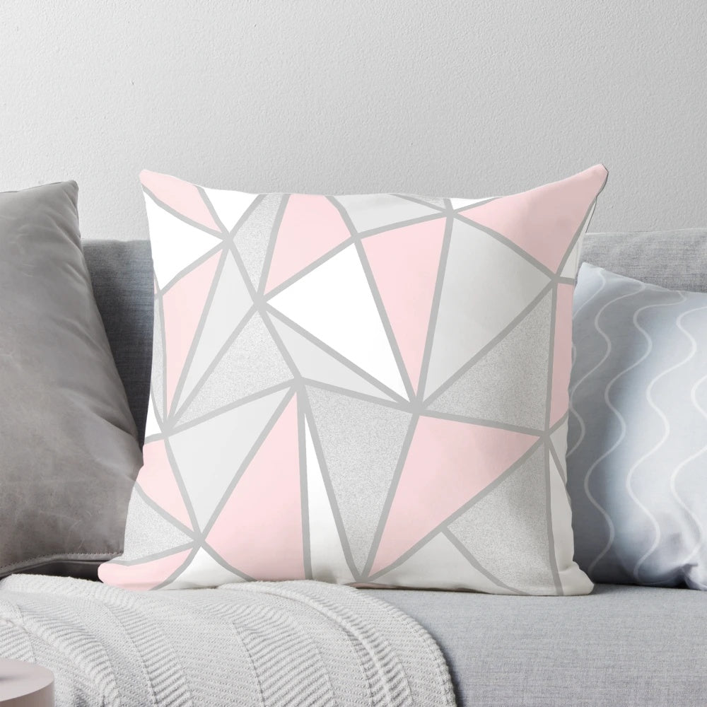 A soft, modern grey and pink geometric throw pillow with a contemporary abstract design