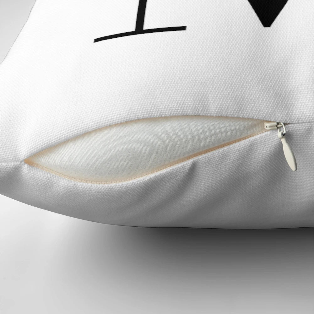 A square decorative throw pillow featuring a green plant motif design in the shape of the letter M.