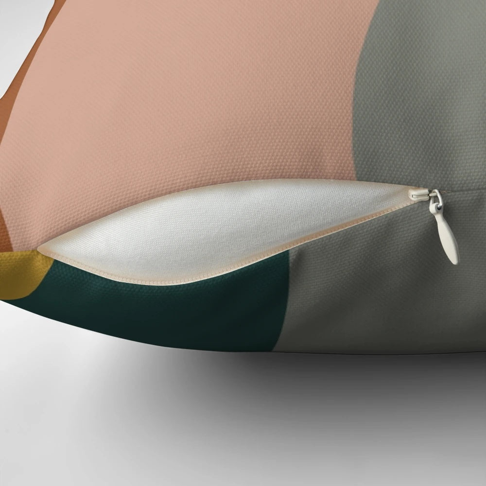 Minimalist pillow featuring an abstract pattern in shades of teal, grey, blush pink, and rust.