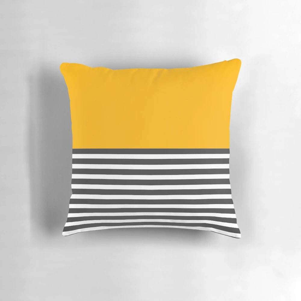 A modern, minimalist throw pillow featuring a half-striped gray and solid yellow design.