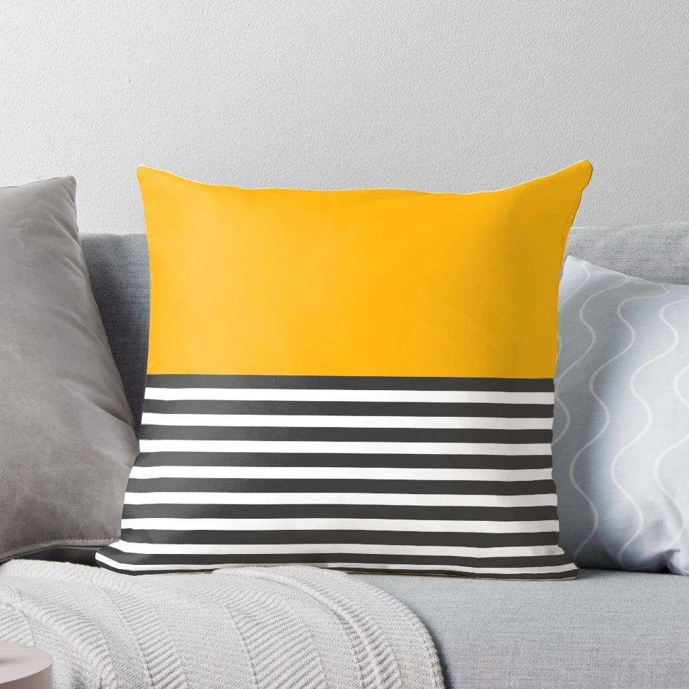 A modern, minimalist throw pillow featuring a half-striped gray and solid yellow design.