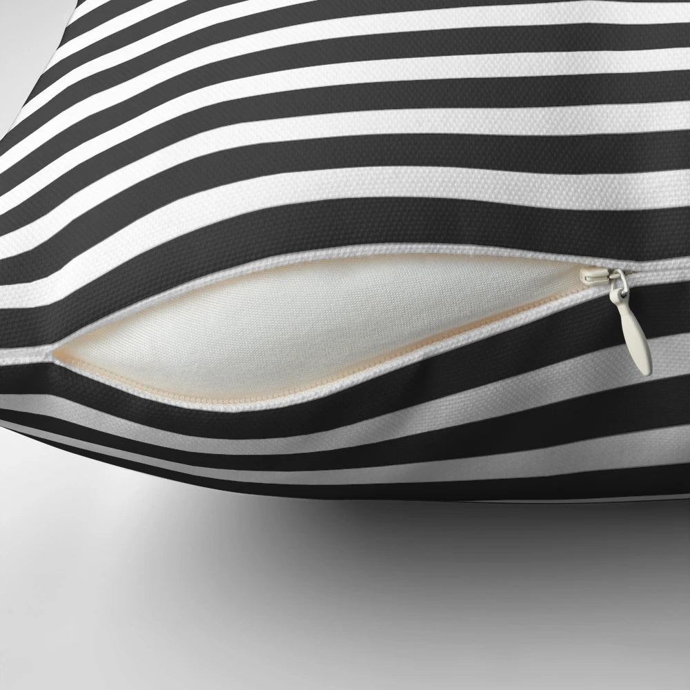 A modern, minimalist throw pillow featuring a half-striped gray and solid yellow design.