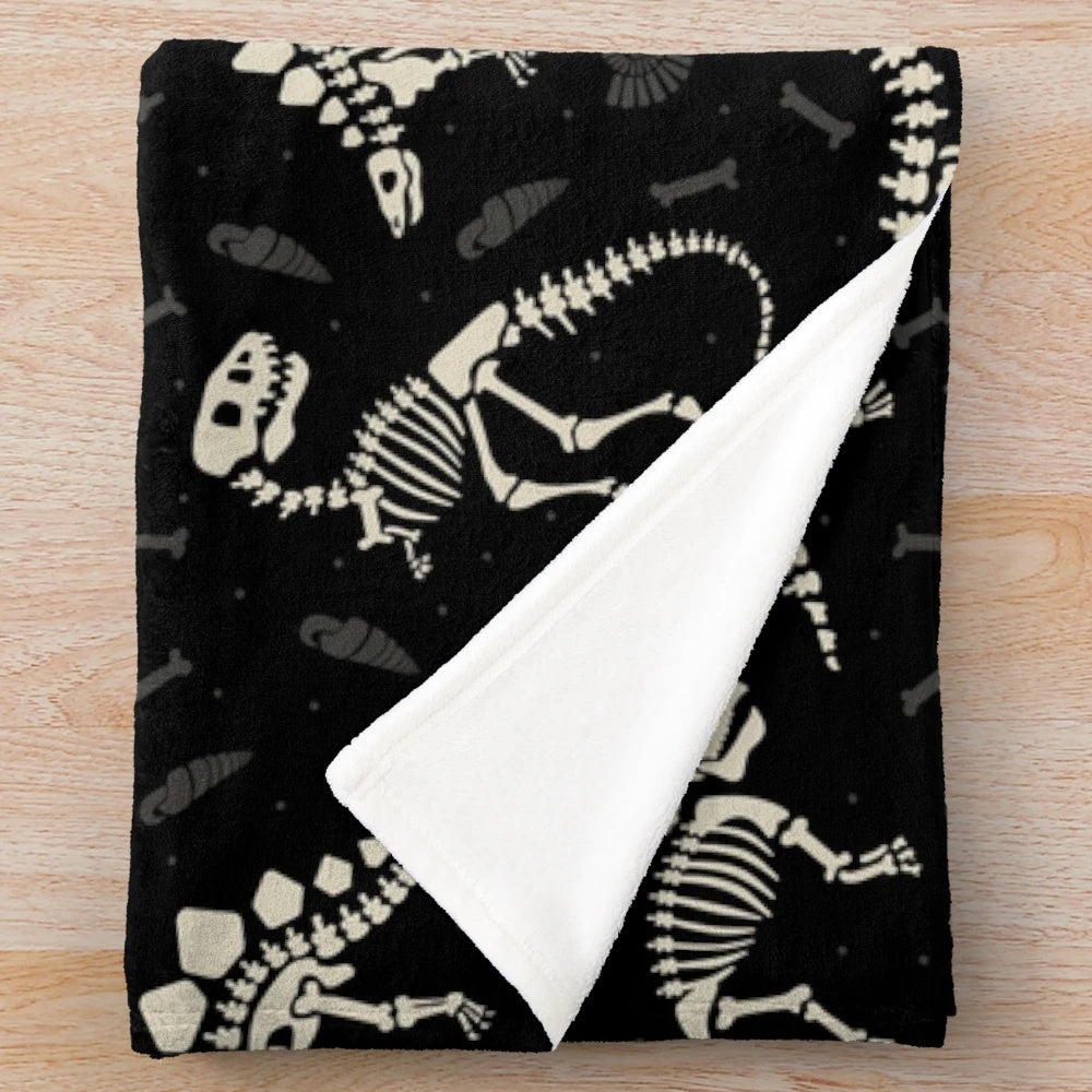 Soft, cozy black and white plush blanket featuring a dinosaur fossil pattern