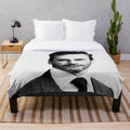 A stylized black and white portrait of actor Jon Hamm printed on a soft, plush blanket