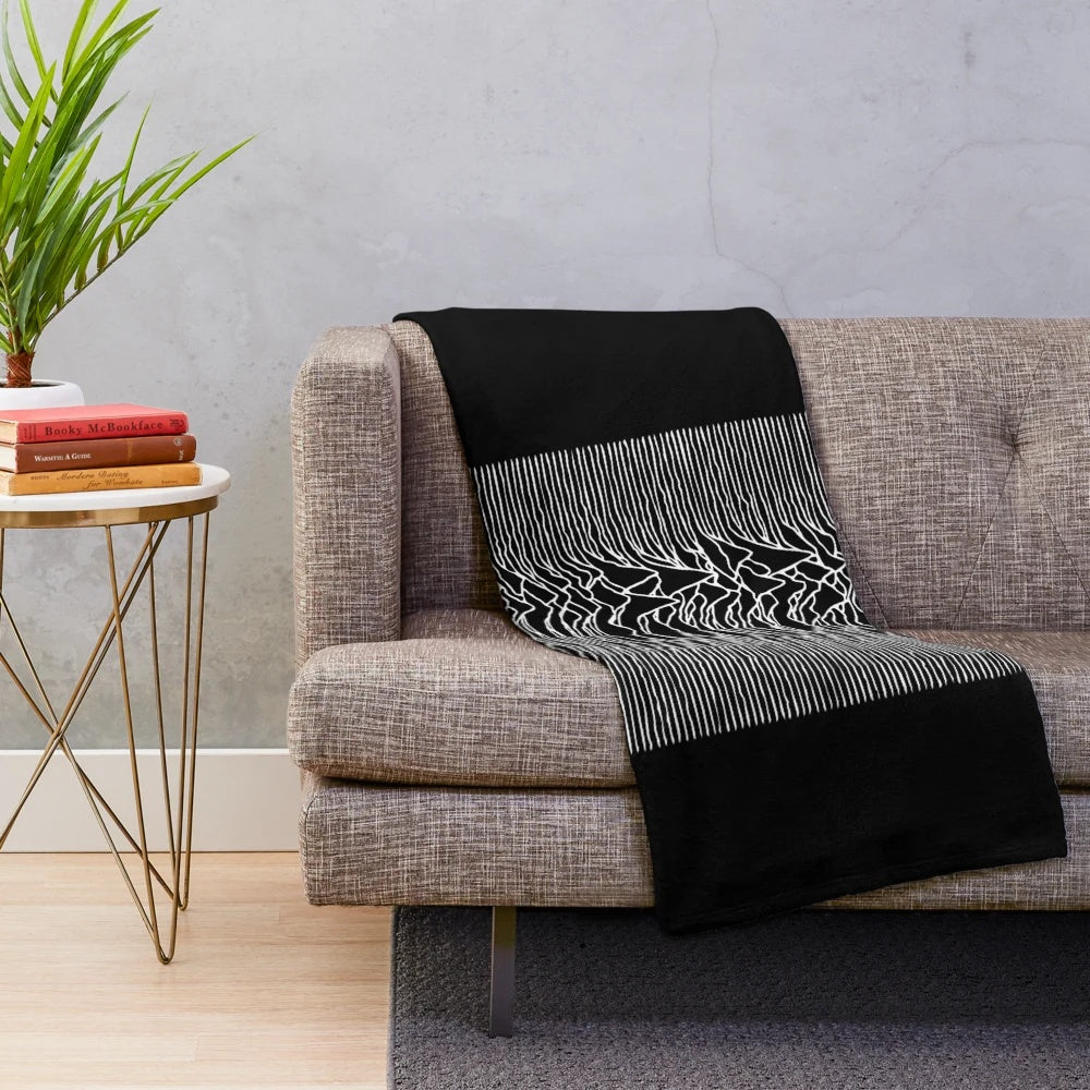 Monochrome plush blanket with 'Unknown Pleasures' album cover-inspired design