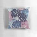 A vibrant, surreal-looking pillow with a monstera leaf design, featuring a blend of blue, pink, and green hues that evoke a tropical, rainy forest atmosphere.