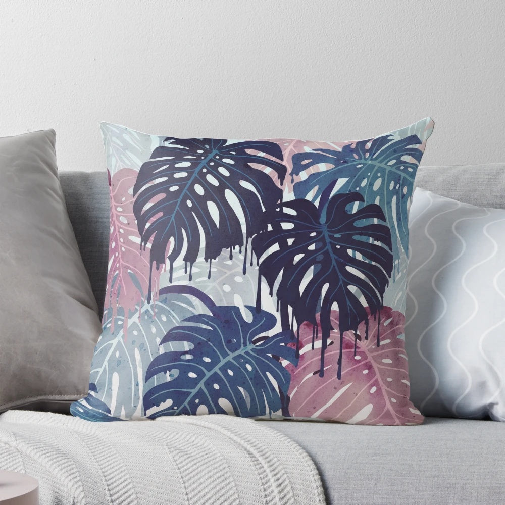 A vibrant, surreal-looking pillow with a monstera leaf design, featuring a blend of blue, pink, and green hues that evoke a tropical, rainy forest atmosphere.