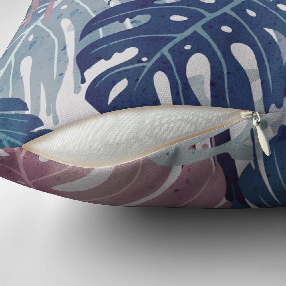 A vibrant, surreal-looking pillow with a monstera leaf design, featuring a blend of blue, pink, and green hues that evoke a tropical, rainy forest atmosphere.