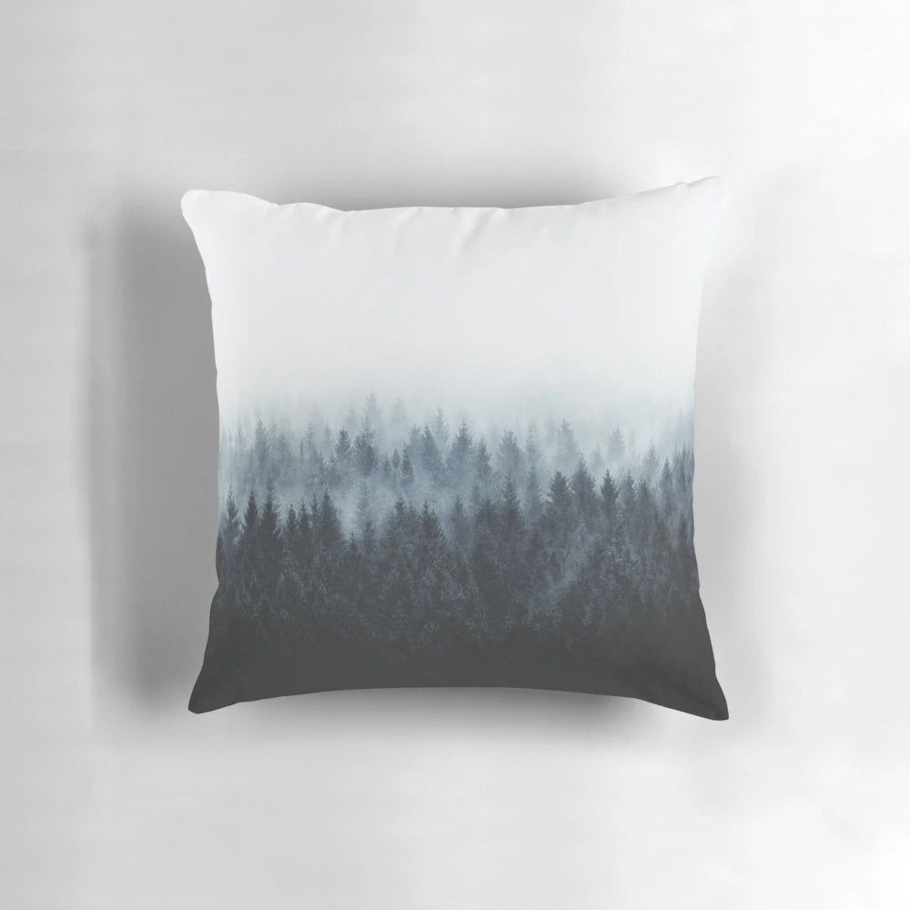 A dark and moody pillow featuring a watercolor-style illustration of a foggy forest with Cascadia trees.