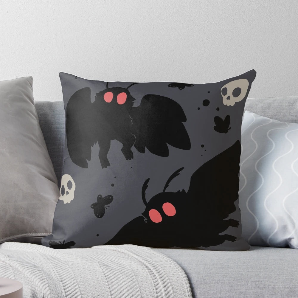 Soft, grey Mothman pillow with a cute, fluffy design and subtle skull motif.