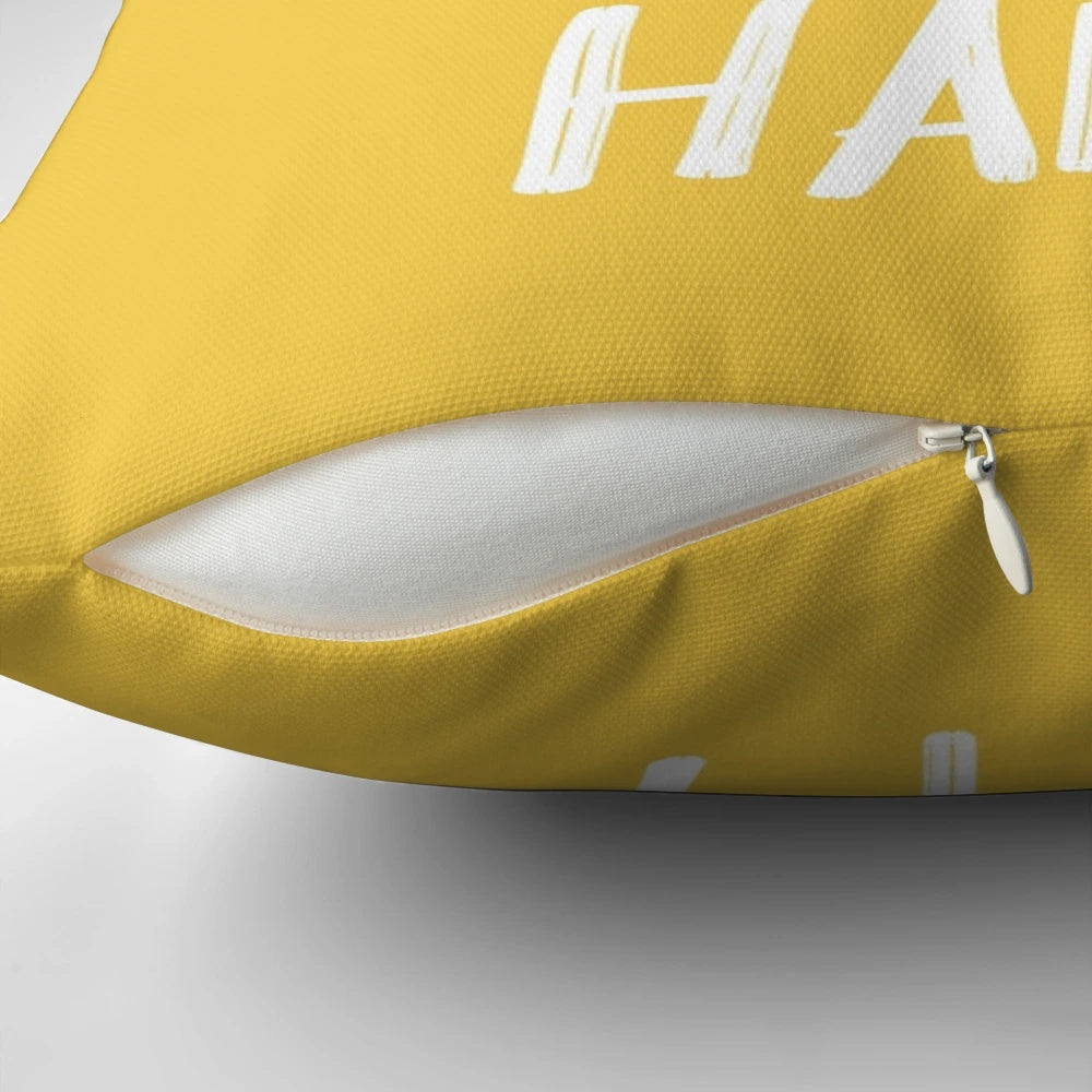 Bright yellow pillow with the text "It's a Good Day to Be Happy" in a fun, typographic design