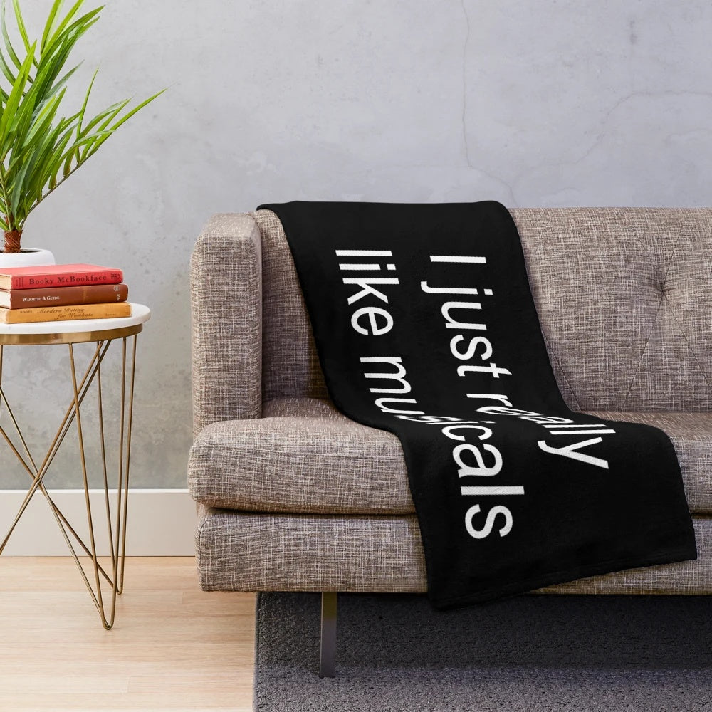 Musical theatre plush blanket with various musical logos and characters