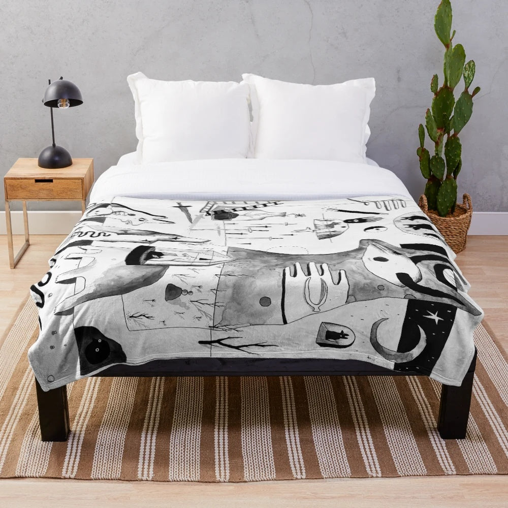 Plush black and white blanket with abstract, spooky desert landscape design