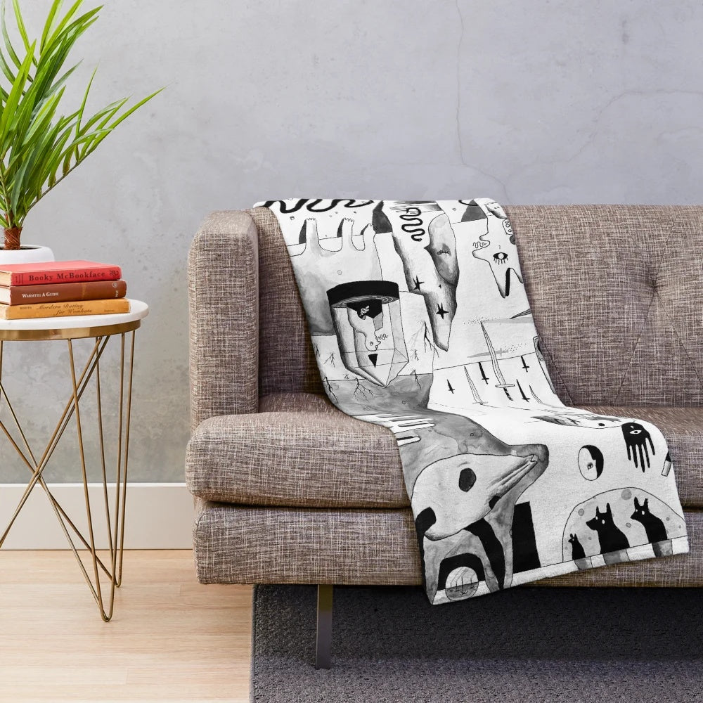 Plush black and white blanket with abstract, spooky desert landscape design