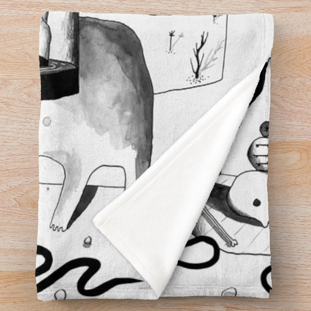 Plush black and white blanket with abstract, spooky desert landscape design
