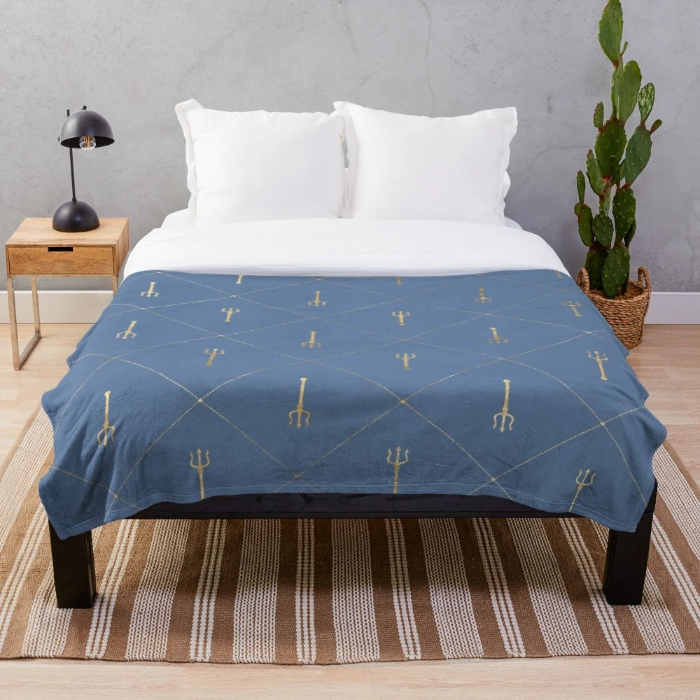 Plush blanket featuring a geometric, Poseidon-inspired design in shades of blue and gold