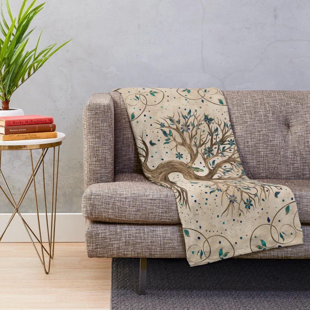 Yggdrasil, the mystic tree of life, depicted on a cozy plush blanket with birds, butterflies, and golden leaves.