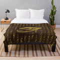 Plush blanket featuring the ancient Egyptian Eye of Horus and hieroglyphics on a wooden background