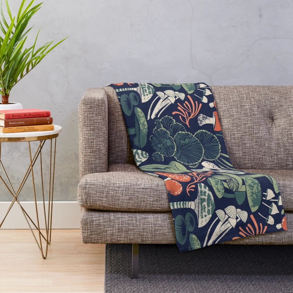 Mystical fungi patterned plush blanket with midnight blue, sage green, forest green, and orange wild mushrooms