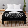 Plush blanket with a mystical moon and moth design for bohemian-style home decor