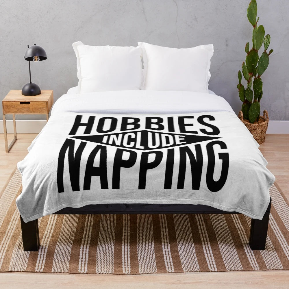 Plush blanket with "Hobbies Include Napping" text