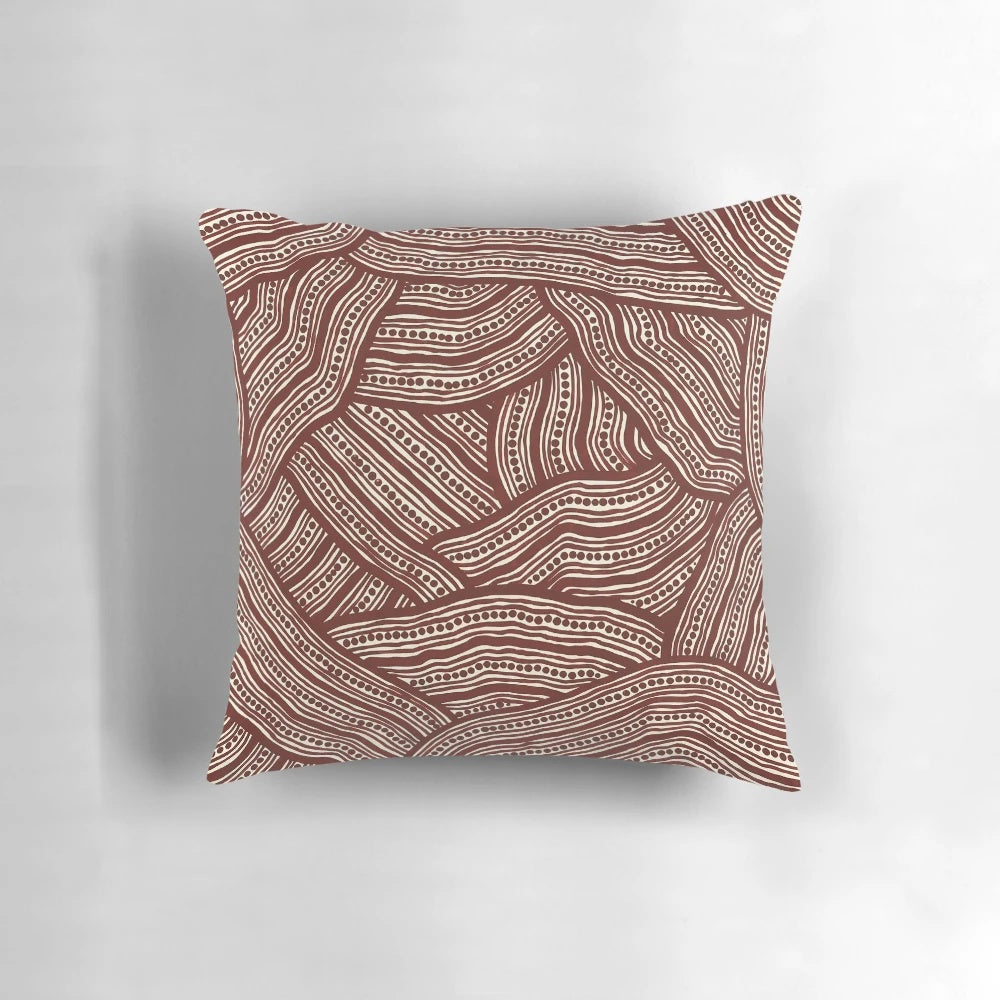 A decorative pillow with a creek bed design, inspired by Australian aboriginal art.