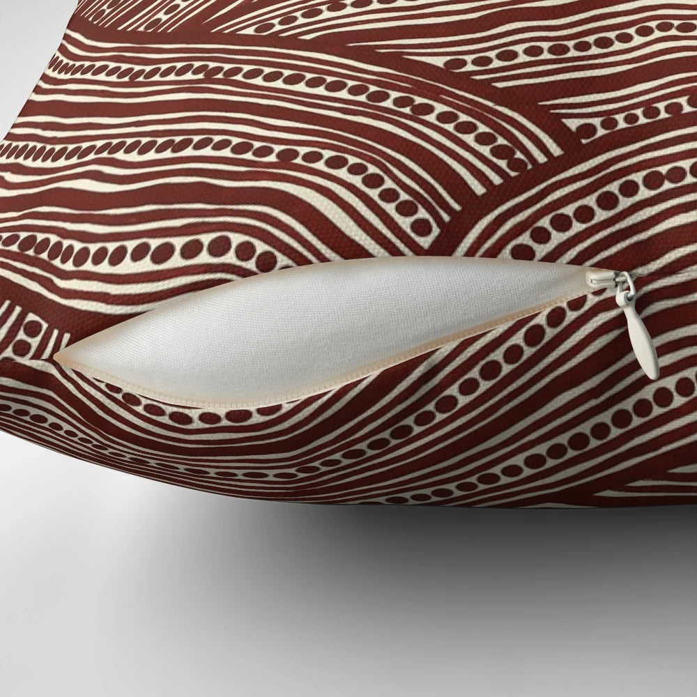 A decorative pillow with a creek bed design, inspired by Australian aboriginal art.