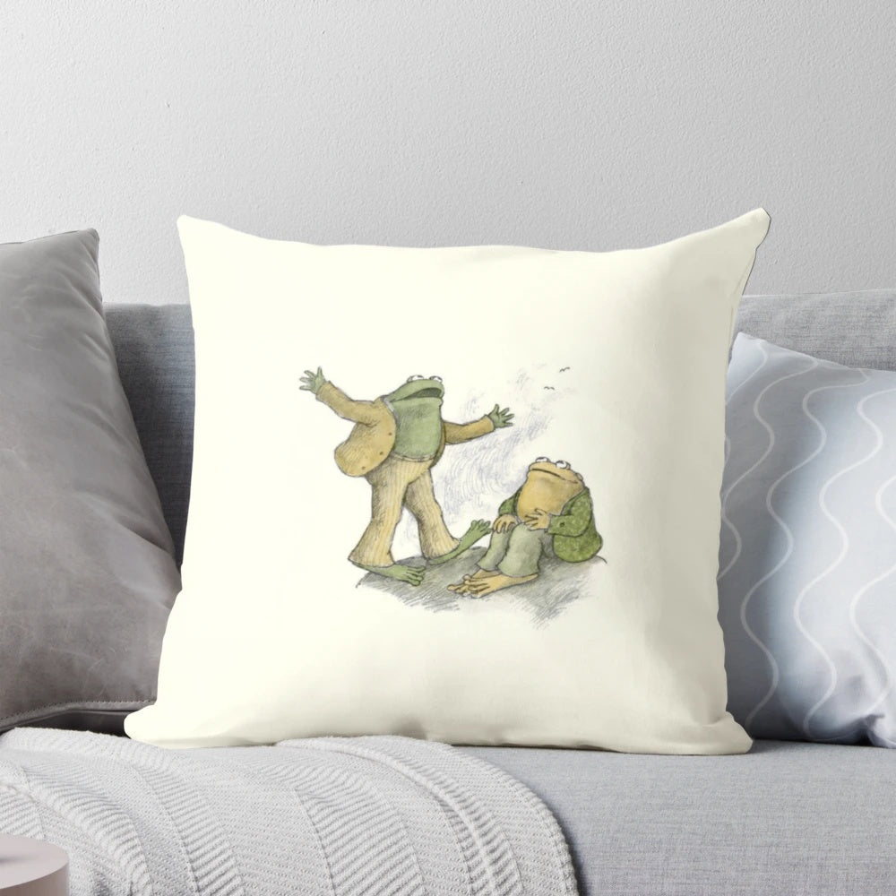 A soft, plush pillow featuring an illustration of two whimsical frogs and toads in a natural setting.