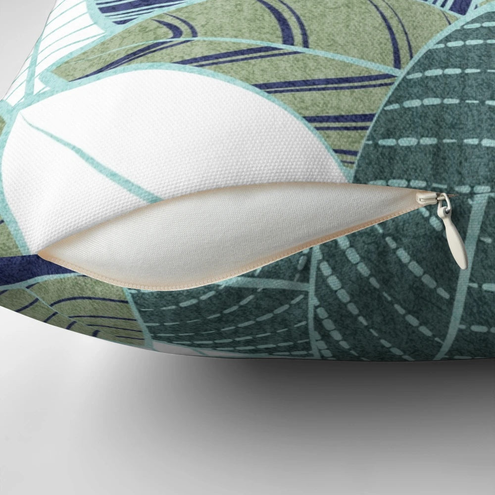 A modern and nature-inspired pillow featuring navy blue, sage green leaves, and mint lines in a beautiful botanical design.
