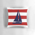 A navy blue pillow featuring a sailboat design against red and white striped background