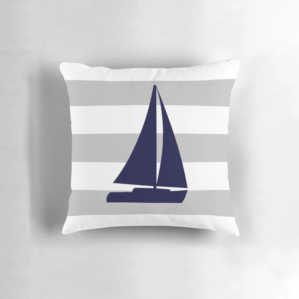 Navy blue and gray striped decorative pillow with a nautical sailboat design