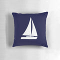 Decorative navy blue pillow with white sailboat silhouette, perfect for nautical-themed home decor