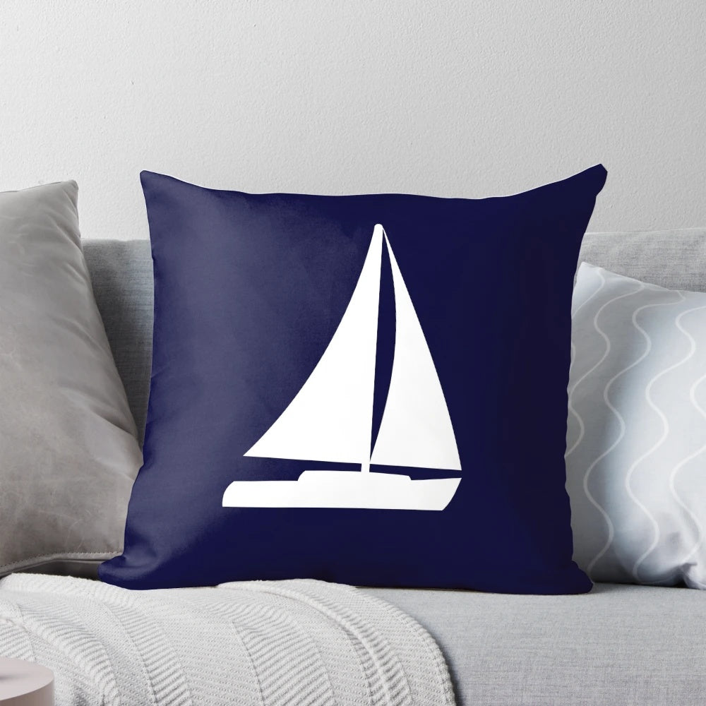 Decorative navy blue pillow with white sailboat silhouette, perfect for nautical-themed home decor