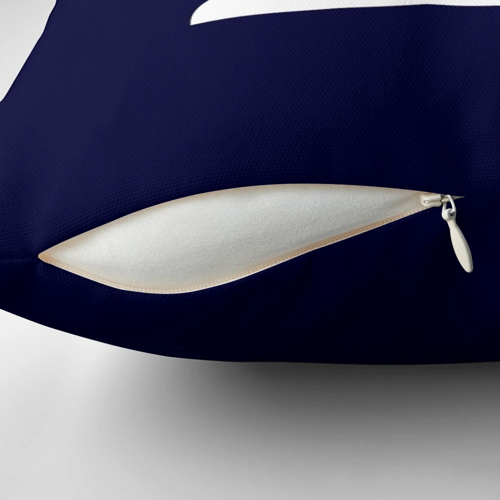 Decorative navy blue pillow with white sailboat silhouette, perfect for nautical-themed home decor