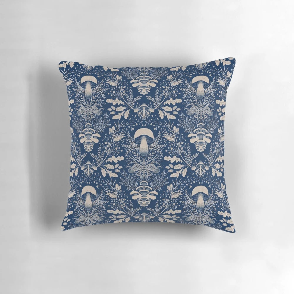 Navy blue and beige damask pattern pillow with illustrations of mushrooms, leaves, and other woodland elements.