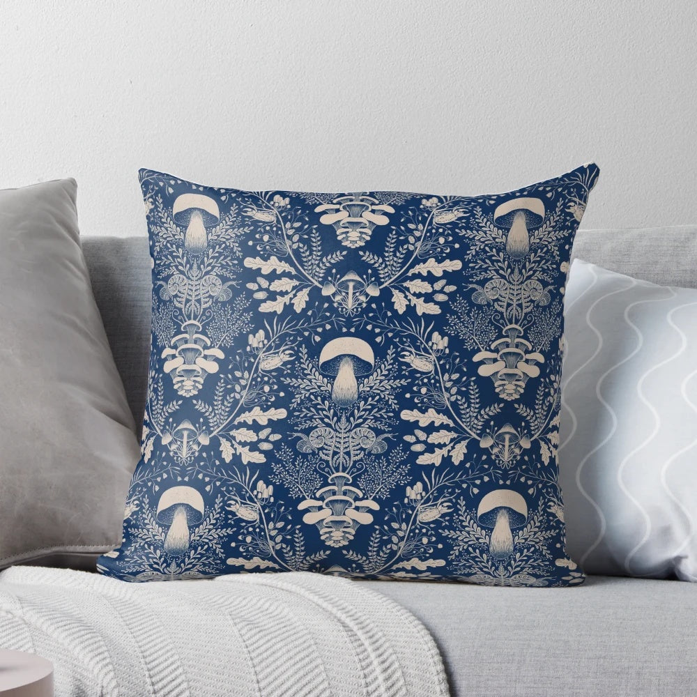 Navy blue and beige damask pattern pillow with illustrations of mushrooms, leaves, and other woodland elements.