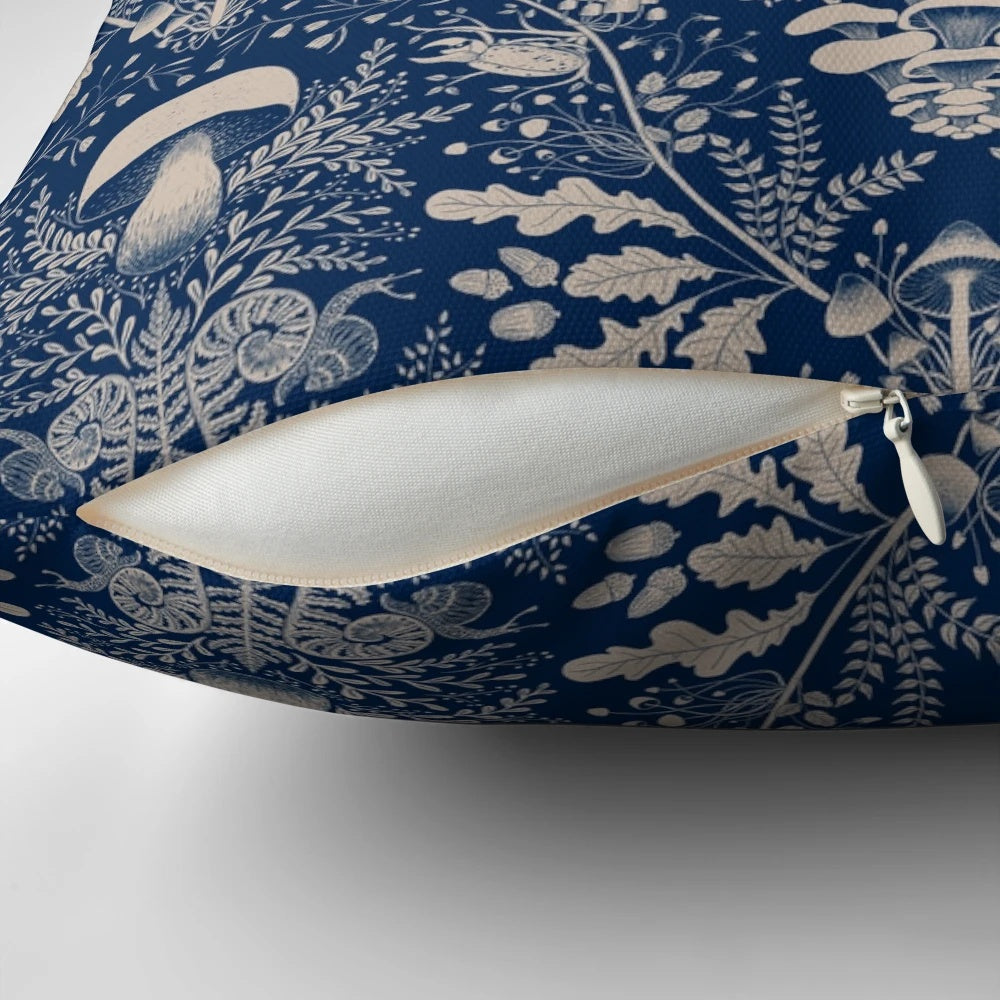 Navy blue and beige damask pattern pillow with illustrations of mushrooms, leaves, and other woodland elements.